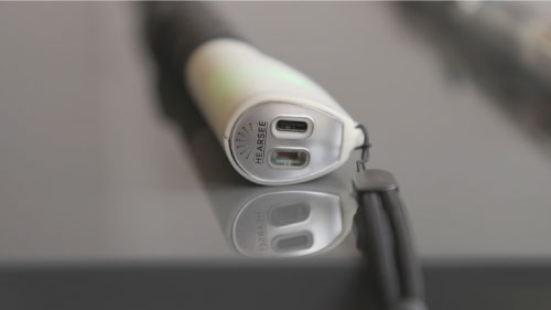 Close-up view of the Hearsee cane prototype’s handle, displaying the sensor module with two ports and a reflective surface underneath.