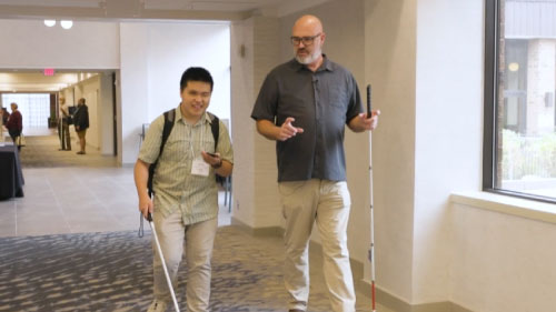 Close-up view of the Hearsee cane prototype’s handle, displaying the sensor module with two ports and a reflective surface underneath.